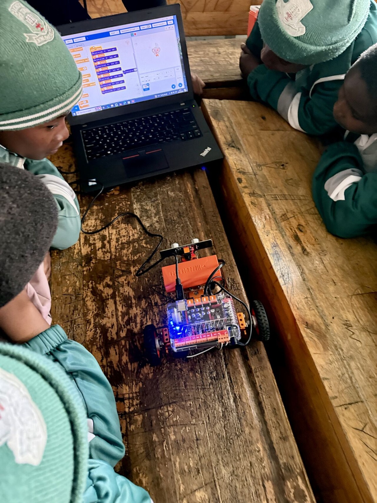 Codewalk students collaborating on a robotics project with Arduino and laptop